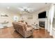 Bright and airy living room featuring a fireplace, ceiling fan, hardwood floors and comfortable seating at 32 Colson Dr, Garner, NC 27529