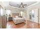 The main bedroom offers a tray ceiling, hardwood floors, neutral tones, and ensuite bathroom at 32 Colson Dr, Garner, NC 27529