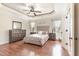 The main bedroom features a tray ceiling, hardwood floors, neutral tones, and furniture at 32 Colson Dr, Garner, NC 27529