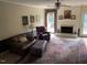 Cozy living room featuring a fireplace, hardwood floors, comfortable seating and access to the patio at 3616 Blue Ridge Rd, Raleigh, NC 27612