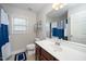 A bathroom featuring a single sink vanity with cherry wood cabinets and a shower/tub combo at 378 Oak Alley Trl, Clayton, NC 27527