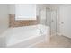 Bathroom featuring a soaking tub with tile surround, next to a glass enclosed shower at 378 Oak Alley Trl, Clayton, NC 27527