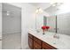 Bathroom featuring a dual sink vanity with cherry wood cabinets and an open doorway at 378 Oak Alley Trl, Clayton, NC 27527