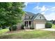 Charming brick home featuring an attached two-car garage, covered front porch, and a well-manicured lawn at 378 Oak Alley Trl, Clayton, NC 27527