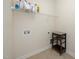 Clean and functional laundry room with tile flooring, shelving, and hookups for a washer and dryer at 378 Oak Alley Trl, Clayton, NC 27527