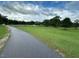 Paved walking path extends through a wide grassy field with trees at 378 Oak Alley Trl, Clayton, NC 27527