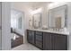 Modern bathroom with a double vanity with dark cabinets, two mirrors, and an open doorway at 3913 Berkeley Town Ln, Fuquay Varina, NC 27526