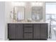 Bathroom features a double vanity with dark cabinets, two mirrors, and a soaking tub by a sunny window at 3913 Berkeley Town Ln, Fuquay Varina, NC 27526