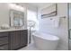 Modern bathroom features a freestanding soaking tub, vanity with dark cabinets, and a glass shower stall at 3913 Berkeley Town Ln, Fuquay Varina, NC 27526