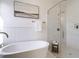 Modern bathroom featuring a soaking tub and a glass-enclosed shower with marble tile surround at 3913 Berkeley Town Ln, Fuquay Varina, NC 27526