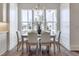 Dining area with a modern chandelier, large windows, and comfortable seating for six at 3913 Berkeley Town Ln, Fuquay Varina, NC 27526
