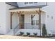 Inviting front porch features wooden columns, black metal railings, and a warm wooden door at 3913 Berkeley Town Ln, Fuquay Varina, NC 27526