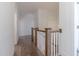 Hallway with wood floors, white walls, white trim and oak railing on the stairway at 3913 Berkeley Town Ln, Fuquay Varina, NC 27526