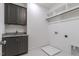 Convenient laundry area features a dark cabinet, a sink, and a tile floor, with washer and dryer hookups at 3913 Berkeley Town Ln, Fuquay Varina, NC 27526