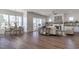 Open-concept living room with hardwood floors, fireplace, and lots of natural light from large windows at 3913 Berkeley Town Ln, Fuquay Varina, NC 27526