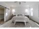 Sun-filled main bedroom with a ceiling fan, wood floors, a bench, a rug, and a sliding barn door at 3913 Berkeley Town Ln, Fuquay Varina, NC 27526