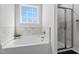 Bathroom showcases a soaking tub, marble tile surround, and glass-enclosed shower at 40 Thunder Valley Ct, Lillington, NC 27546