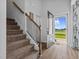 Bright foyer with an open front door, staircase, and hardwood floors at 40 Thunder Valley Ct, Lillington, NC 27546