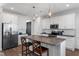 Open kitchen features white cabinets, stainless steel appliances, and a kitchen island with a granite countertop at 40 Thunder Valley Ct, Lillington, NC 27546