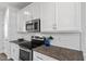 Kitchen features white cabinets, stainless steel microwave, granite countertops, and white subway tile backsplash at 40 Thunder Valley Ct, Lillington, NC 27546