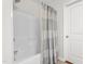 Bright bathroom featuring a shower-tub combo with a stylish gray and white striped shower curtain at 4052 Dunkirk Dr, Burlington, NC 27215