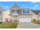 Charming two-story home boasts a well-maintained lawn, two-car garage, and inviting front porch at 4052 Dunkirk Dr, Burlington, NC 27215