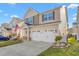 View of the home's front, highlighting the attached two-car garage and meticulously landscaped front yard at 4052 Dunkirk Dr, Burlington, NC 27215