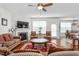 Cozy living room featuring a fireplace, ceiling fan, hardwood floors, and comfortable seating arrangements at 4052 Dunkirk Dr, Burlington, NC 27215
