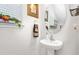 Stylish powder room features a pedestal sink, round mirror, and decorative accents, offering a fresh aesthetic at 4052 Dunkirk Dr, Burlington, NC 27215