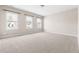 Spacious bedroom features neutral carpet and three bright windows looking out onto the neighborhood at 428 Boulder Point Dr, Chapel Hill, NC 27516