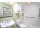 Bright bathroom features white tile shower, matching toilet and pedestal sink, plus useful built-in storage at 513 Princeton St, Raleigh, NC 27609