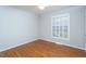 Bedroom featuring hardwood floors, neutral paint, and a window providing natural light and outdoor views at 513 Princeton St, Raleigh, NC 27609