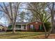 Lovely single-story brick home surrounded by mature trees and lush greenery at 513 Princeton St, Raleigh, NC 27609