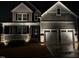 Charming two-story home with a welcoming front porch, stone accents, and a two-car garage at night at 525 Marion Hills Way, Knightdale, NC 27545