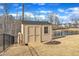 Backyard shed with double doors, adjacent to a black fence and a retention pond at 525 Marion Hills Way, Knightdale, NC 27545