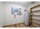 Basement utility area with a hot water tank, shelving, and electrical panel at 582 Pollyanna Rd, Henderson, NC 27537