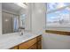 Bathroom vanity features wood cabinets, a white marble countertop, and a window with natural light at 582 Pollyanna Rd, Henderson, NC 27537