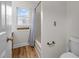 Bathroom features a tub with blue shower curtain, wood-look flooring, and a window for natural light at 582 Pollyanna Rd, Henderson, NC 27537