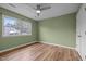 Bedroom with soothing green walls, wood-look flooring, ceiling fan and large window for natural light at 582 Pollyanna Rd, Henderson, NC 27537