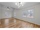 Light-filled bedroom featuring hardwood floors, neutral walls, and multiple windows that offer a pleasant view at 582 Pollyanna Rd, Henderson, NC 27537