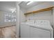 Small laundry room features a full-size washer and dryer and wooden shelf at 582 Pollyanna Rd, Henderson, NC 27537