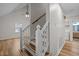View of the wooden staircase with white railings adjacent to the living area, blending functionality with stylish design at 582 Pollyanna Rd, Henderson, NC 27537