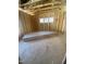 Bedroom under construction, showing framing, a window with natural light, and wood flooring at 60 Valebrook Ct, Youngsville, NC 27596