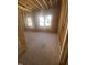 Bedroom construction showcasing framing, natural light from the window, and wood flooring at 60 Valebrook Ct, Youngsville, NC 27596