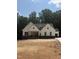 New construction home with white siding, stone accents, and a well-lit front porch at 60 Valebrook Ct, Youngsville, NC 27596