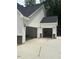 Spacious three-car garage with white siding, stone accents, and ample parking space at 60 Valebrook Ct, Youngsville, NC 27596