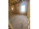 Guest bedroom under construction, showcasing framing, wood flooring, and natural light at 60 Valebrook Ct, Youngsville, NC 27596