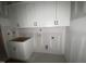 Well-lit laundry room space featuring upper and lower white cabinets, ready for appliances at 60 Valebrook Ct, Youngsville, NC 27596