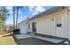 Home's exterior with a concrete patio, lush green lawn and mature trees provide privacy at 613 Flaherty Ave, Wake Forest, NC 27587