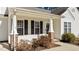 Inviting front porch with brick accents and well-manicured landscaping adds curb appeal at 613 Flaherty Ave, Wake Forest, NC 27587
